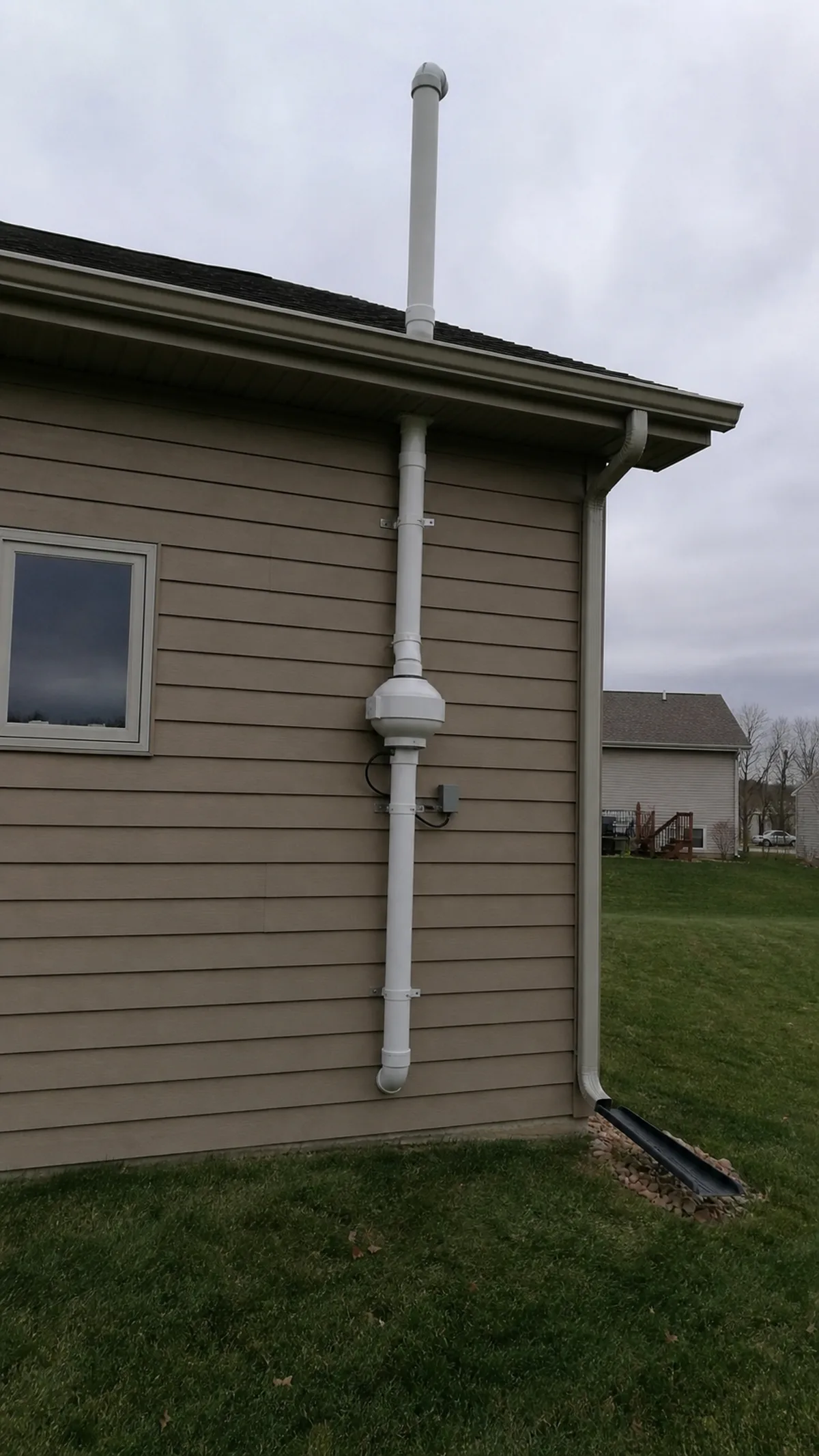 Radon mitigation pipe and fan installed on the exterior of a Lincoln home